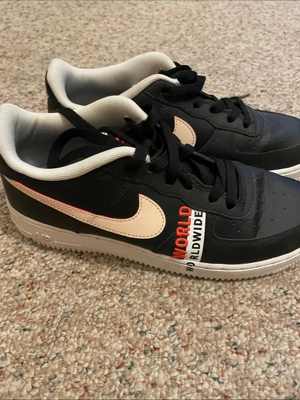Nike Kids Black Sneakers with Cream Swoosh and Orange Accents
